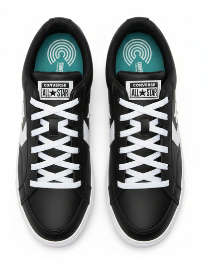 A pair of Converse All Star sneakers in black and white, shown from a top-down view with their black shoebox behind them.